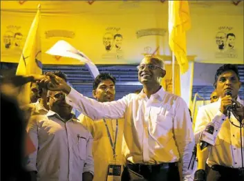  ?? Eranga Jayawarden­a/AP Photo ?? Maldives' opposition presidenti­al candidate, Ibrahim Mohamed Solih, center, shakes hands with a supporter Monday as his running mate, Faisal Naseem, right, addresses a gathering in Male, Maldives.