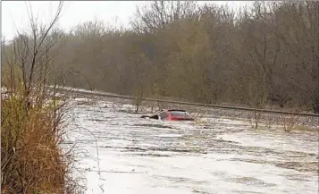  ?? LAYTON HOYER VIA AP ?? A red SUV is seen submerged in floodwater in Granby, Mo., Friday. A woman was rescued from the car.