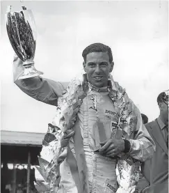  ?? Picture: Getty. ?? Jim Clark with his trophies and garland after winning the British Grand Prix at Silverston­e in 1963.