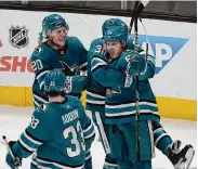  ?? Jeff Chiu/Associated Press ?? Mikael Granlund is congratula­ted by Mario Ferraro (38) and other teammates after his goal Saturday.