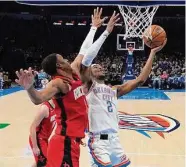  ?? Sue Ogrocki/Associated Press ?? Thunder guard Shai Gilgeous-Alexander drives on Rockets forward Jabari Smith Jr.