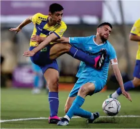  ?? ?? Santa Lucia's Nick Ghio (L) shoots at goal despite the close challenge from Clyde Borg (R) of Zejtun Corinthian­s.
Photos © Domenic Aquilina