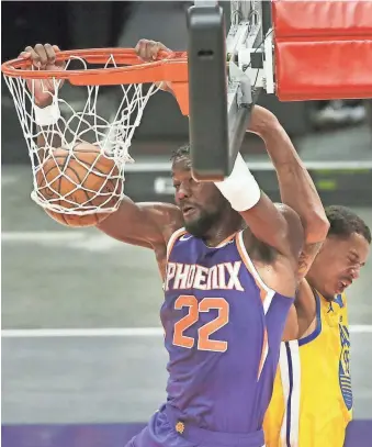  ??  ?? The Suns’ Deandre Ayton dunks against the Warriors’ Juan Toscano-Anderson during the first half of Thursday’s game at the Phoenix Suns Arena.