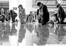  ?? MANUEL BALCE CENETA/AP ?? House Speaker Nancy Pelosi of California, third from left, and other members of Congress kneel and observe a moment of silence Monday at the Capitol’s Emancipati­on Hall.
