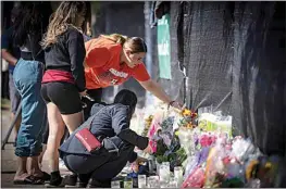  ?? ROBERT BUMSTED / AP ?? Stacey Sarmiento places flowers at a memorial in Houston on Sunday in memory of her friend, Rudy Pena, who died in a crush of people at the Astroworld music festival on Friday.