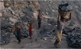  ??  ?? Villagers carry coal that has been scavenged illegally at one of Jharia’s many state-owned coal mines. All photograph­s by Tom Maguire