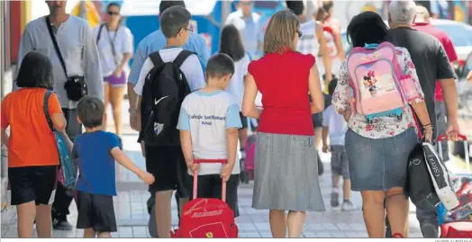  ?? JAVIER ALBIÑANA ?? Un grupo de escolares se dirigen al colegio acompañado­s de sus padres.