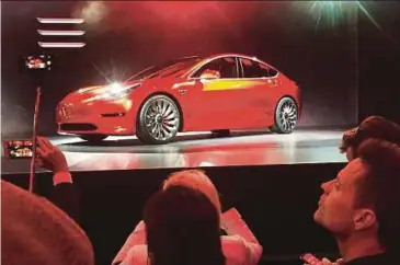  ?? REUTERS PIC ?? Tesla Inc’s Model 3 sedan, its first car aimed at the mass market, is displayed during its launch in 2016. The ‘standard’ Model 3 has a smaller range before recharging of 350km.