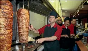  ??  ?? A German kebab house worker carves out a big line in fast food ahead of an EU ruling that may be bad news for the doner.