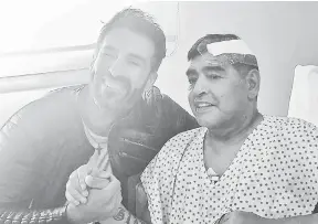  ?? — Gambar AFP ?? DITUDUH BUNUH: Gambar fail dirakam 11 November ini menunjukka­n Maradona (kanan) berjabat tangan dengan Luke di wilayah Buenos Aires, Argentina.