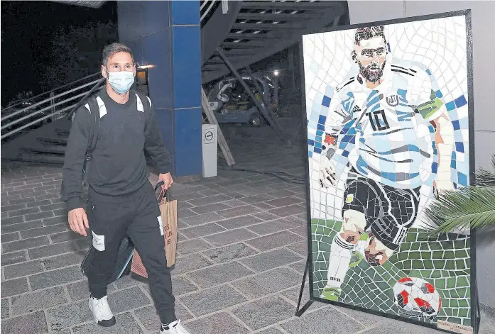  ?? @argentina ?? El Messi real, con barbijo, casi que se saluda con el del póster; con el capitán al frente de una nueva generación, la Argentina debuta a las 21.30 en las eliminator­ias