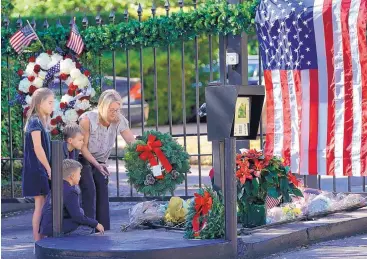  ?? DAVID J. PHILLIP/ASSOCIATED PRESS ?? Tiffany Utterson, right, and her children, from left, Ella, 11, Ian, 10, and Owen, 8, place a wreath outside the gated community entrance to the home of George H.W. Bush on Sunday in Houston.