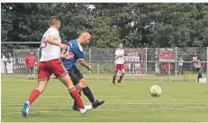  ?? RP-FOTO: NIPKO ?? Mit diesem Linksschus­s trifft Nico Jelinsky (blaues Trikot) zum 1:0 für Hilfarth, Helpenstei­ns Maik Verbocket (Nr. 5) kann‘s nicht verhindern.