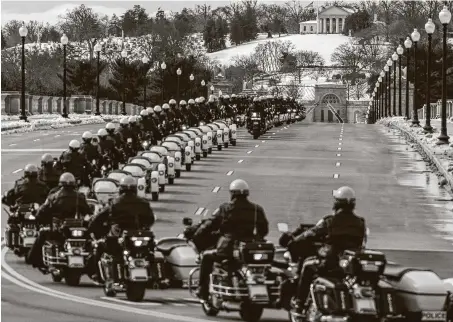  ?? Andrew Harnik / Associated Press ?? U.S. Capitol Police officers ride ahead of the hearse of Capitol Police officer Brian Sicknick on its way to Arlington National Cemetery.