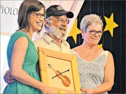  ?? DESIREE ANSTEY/JOURNAL PIONEER ?? Carole Gallant, left, and Caroline Arsenault, present the Golden Fiddle Award to Jacques Arsenault during the Atlantic Fiddlers’ Jamboree recently.