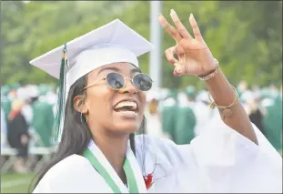  ?? Alex von Kleydorff / Hearst Connecticu­t Media ?? Above, Samrah Sawyer gives the OK sign to family and friends in the crowd as she graduates with the Norwalk High School class of 2018 during commenceme­nt on Monday in Norwalk. At right, Jeremy Jimenez shows off his diploma to classmates during graduation.