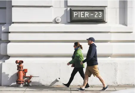  ?? Photos by Paul Chinn / The Chronicle ?? People stroll past Pier 23, a site that Supervisor Aaron Peskin proposed then dropped for a homeless Navigation Center.