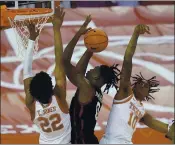  ?? ERIC GAY — THE ASSOCIATED PRESS ?? Oklahoma forward Victor Iwuakor, center, is pressured by Texas forward Kai Jones, left, and guard Donovan Williams as he eyes the basket during the first half Tuesday night.