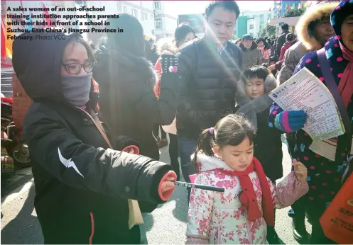  ?? Photo: VCG ?? A sales woman of an out-of-school training institutio­n approaches parents with their kids in front of a school in Suzhou, East China’s Jiangsu Province in February.