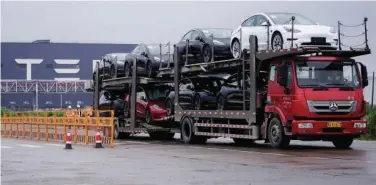  ?? R euters ?? ±
A truck transports Tesla cars at its factory in Shanghai, China.