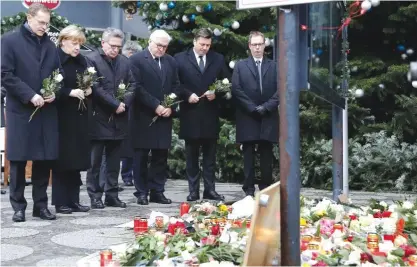  ??  ?? BERLIN: (From Left) The Mayor of Berlin Michael Mueller, German Chancellor Angela Merkel, German Interior Minister Thomas de Maiziere and German Foreign Minister Frank-Walter Steinmeier attend a flower ceremony at the Kaiser-Wilhelm Memorial Church. — AP