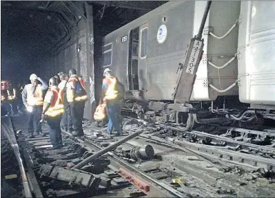  ?? [TRANSPORT WORKERS UNION, LOCAL 100] ?? Workers from the New York Metropolit­an Transporta­tion Authority examine damaged train tracks at the scene of a subway derailment Tuesday near a station in the Harlem neighborho­od.