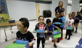  ?? JOHN RAOUX — THE ASSOCIATED PRESS ?? In this Tuesday photo, students return to their classrooms after they were given school supplies, including pencils and books at Riverdale Elementary School, in Orlando, Fla. The exodus from Hurricane Maria has added to what already has been in influx...