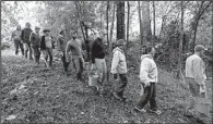  ?? AP/GERRY BROOME ?? Furloughed employees from the Environmen­tal Protection Agency march Thursday into a woods along the Eno River in Hillsborou­gh, N.C., to do volunteer maintenanc­e on a public canoe access point.