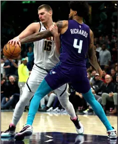  ?? DAVID JENSEN — GETTY IMAGES ?? Nick Richards of the Charlotte Hornets defends Denver’s Nikola Jokic as he drives to the basket in the second half Saturday at Spectrum Center in Charlotte, N. C.