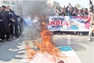  ??  ?? Students of Islami Jamiat Talaba (IJT), a wing of religious political party Pakistan Jamaat-e-Islami (JI), burn an Indian flag and chant slogans during an anti-India protest rally, in Lahore. — AFP photos