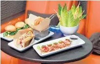  ??  ?? The signature dishes at iPic Theatre include turkey sliders, a lobster roll with Old Bay potato chips, and (front) spicy tuna on crispy rice.