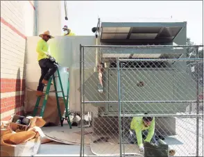  ?? Christian Abraham / Hearst Connecticu­t Media ?? Workers from KMK Insulation of North Haven finish working on the new dedicated outdoor air system, or DOAS, at Westover Elementary School in Stamford on Friday.