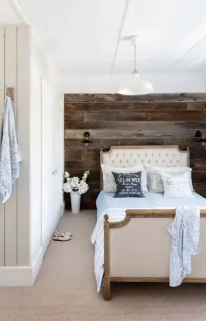  ??  ?? MAIN BEDROOM Reclaimed barn wood, bought from a local timber yard, makes the perfect backdrop for the oakframed upholstere­d Loire bed from Feather & Black. The Cult Living factory-style wall lights are from Cult Furniture, and the central light is the...