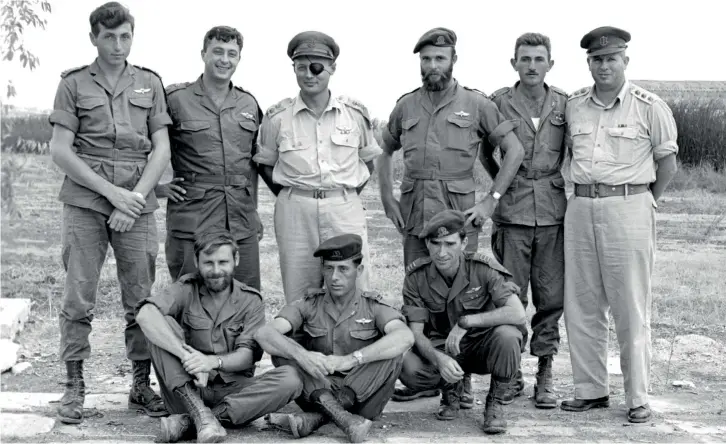  ?? (Reuters) ?? ARIEL SHARON (standing, second from left) is shown together with Moshe Dayan (standing, third from left) and other military commanders in October 1955.