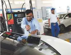  ?? Abdul Rahman/Gulf News ?? Motorist Mohammad Farooq cleans his car window after using the self-service lane to refuel at an Adnoc pump yesterday.