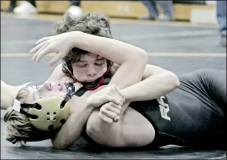  ?? Photo by Tom Hendrixson ?? Wapakoneta’s Caden Mellott puts the squeeze on Ben Logan’s Landon Zehner. The WHS freshman went on to win the 113-pound division championsh­ip at the Mccracken Wrestling Tournament on Saturday in Sidney.