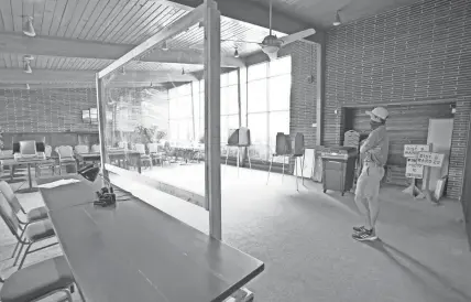  ?? JOURNAL SENTINEL MIKE DE SISTI / MILWAUKEE ?? Currie Golf Course golf starter Patrick Niederjohn stands in a polling location that is set up with plexiglass to protect voters and poll workers at Currie Golf Course on North Mayfair Road in Wauwatosa on Monday.