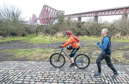  ?? Picture: Wullie Marr. ?? Willie Rennie MSP runs accompanie­d by his son near the Forth Bridge.