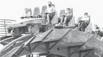  ?? DAN LEAVELLE ?? Riders wearing face masks crest the first hill of SeaWorld Orlando’s Mako roller coaster on Tuesday.