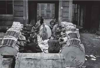  ??  ?? ■ Right: Spartacist­s defending themselves behind barricades made from newspaper bundles and newsprint paper rolls in front of the Mosse building, home of the ‘Berliner Tageblatt’ newspaper, Schützenstraße, at the corner of Jerusaleme­rstraße, January 1919.
■ Left: A roadblock manned by members of the Berliner Einwohnerw­ehr, January 1919.