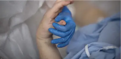  ?? Picture: AFP ?? HIGH CARE. A medical staff member holds the hand of a patient infected with Covid-19 at the intensive care unit of the Clinique Oceane private hospital in Vannes, western France, this week.