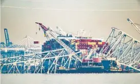  ?? JERRY JACKSON/STAFF ?? A crane lifts a container from the Dali on April 8, nearly two weeks after the ship lost power and hit a pier of the Francis Scott Key Bridge, causing a catastroph­ic collapse that left six people dead.