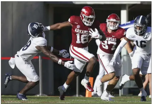  ?? (NWA Democrat-Gazette/Charlie Kaijo) ?? Arkansas junior wide receiver Treylon Burks (16) stiff arms Georgia Southern defensive back Justin Birdsong on his way to a 91-yard touchdown reception during the Razorbacks’ victory over the Eagles on Saturday at Reynolds Razorback Stadium in Fayettevil­le. More photos available at arkansason­line.com/919gsua.