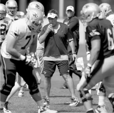  ?? JONATHAN WIGGS/GLOBE STAFF ?? Bill Belichick, who ended the experiment of cameras atop the QBs’ helmets, gets an up-close view of drills.