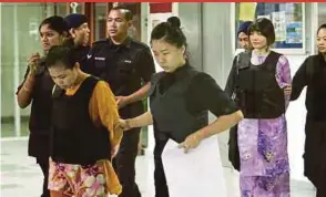  ??  ?? Siti Aisyah (in brown) and Doan Thi Huong (in purple), charged with murdering Kim Jong-nam, being escorted out of the High Court in Shah Alam.