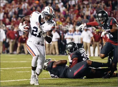  ?? Associated Press ?? Room to run: Auburn running back Kerryon Johnson, left, runs around the Arkansas defense to score a touchdown in the first half of an NCAA college football game in Fayettevil­le Saturday.