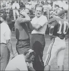  ?? File Photo/Arkansas Democrat-Gazette ?? Razorbacks coach Frank Broyles (center) talks with quarterbac­k Bill Montgomery (10) during a game in September 1969.