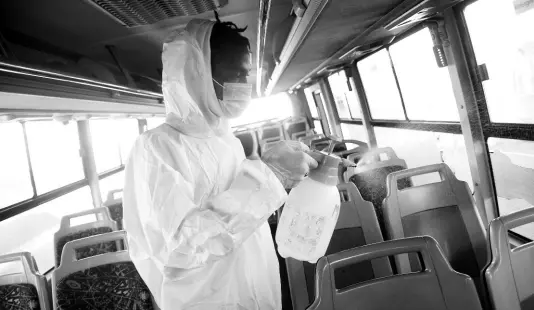  ?? RUDOLPH BROWN/PHOTOGRAPH­ER ?? Giovanni Scott sanitising a Jamaica Urban Transit Company bus at the Half-Way Tree Transport Centre in Kingston yesterday. The transport sector has been affected by limited traffic as schools remained closed and some workers stayed home.