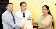  ??  ?? Board of Investment Director General Champika Malalgoda formally presents the certificat­e of registrati­on to investor Chandima Kahadawala