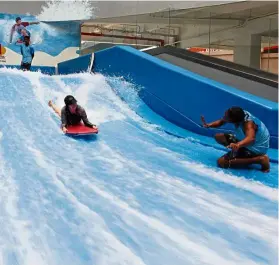  ??  ?? Do you dare to ride the flow? An insturctor showing his moves at the FlowRider facility (above). An instructor giving the writer some tips. — Photos: GLENN GUAN/The Star